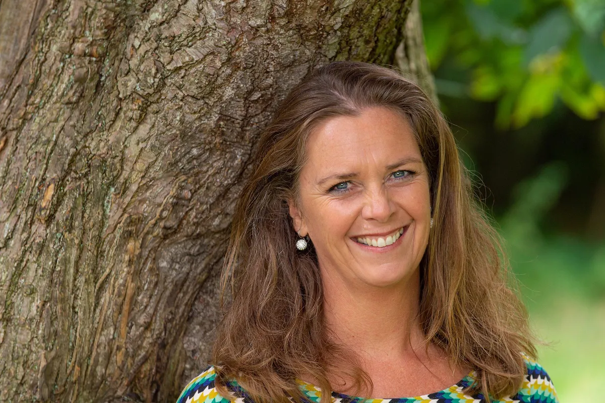 Jozalinda de Schipper lachend tegen een boom